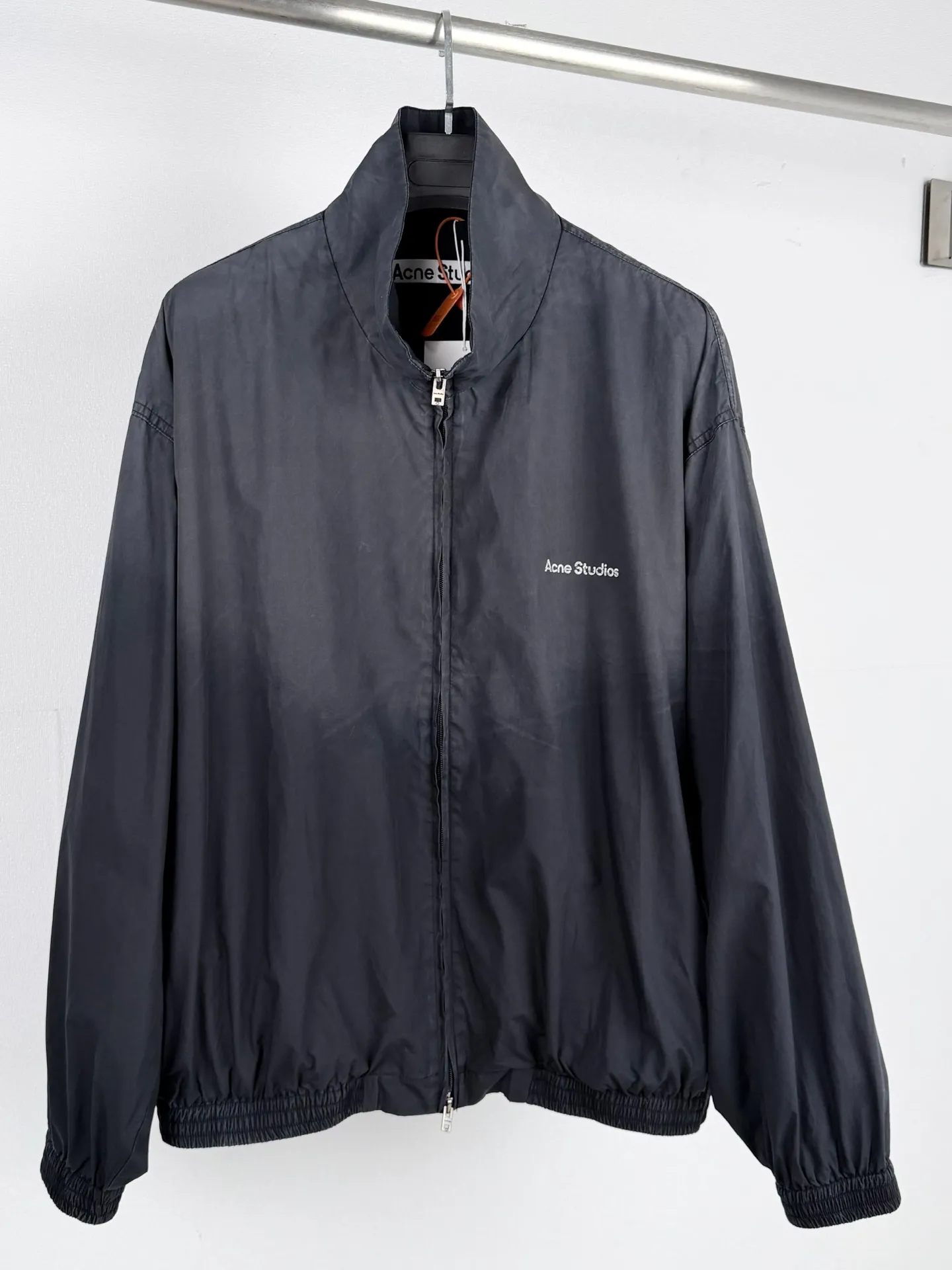 ACNE Studios Contrast Logo Distressed Zip Jacket Custom-made Dusty Royal Poplin Lightweight and crisp Dry and wind-resistant Sophisticated Royal Blue smudged body Washed mist softens the bright tones Interpreting the cool and relaxed luxury unique to Scandinavia Stand-up collar fully zippered coach jacket Elasticated hem cuffs Create a relaxed, drop-top short silhouette Fully lined interior with a smooth and neat upper body The Acne Studios print is discreetly engraved on the chest, retaining the brand gene in a restrained and subtle manner. The contrasting Acne Studios Retro emblem is laid out on the back of the garment. One simple and one complex form a clever visual contrast, which reflects the brand's heritage and traces back to the origin of the brand. It uses the Nordic minimalist high-end ready-to-wear language to describe the narrative of relaxed and restrained luxury and elegance. Process 1: Adopt glue printing process. The printing has been revised three times with the film screen. Use glue liquid paint to print the pattern on the fabric. Bake the fabric to fix the printed pattern. Process 2: Gradient distressed spray process. By spraying dyes of different colors on the surface of the fabric, the clothes can show rich color changes under different lights and increase the visual layering. Process 3: Heavy fermentation washing uses a special solution to remove stains and slight fading, and then snowflake washing. Use strong washing to fade the color to make the color more uniform. Process 4: The hem is made in one go using a three-needle waist-drawing machine. The elastic band and the fabric are sewn together in the same process using the special needle position and feeding mechanism of the machine. The three-needle design is more secure and can distribute pressure evenly to ensure that the elastic band and the fabric fit tightly. Accessories: Customized 1:1 Acne zipper Customized 1:1 Acne trademark Fit: Loose fit Size: 44 46 48 50